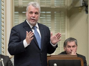 In this file picture from Thursday, February 19, 2015, Quebec Premier Philippe Couillard responds to Opposition questions over the strip search by high school officials of a female student as then Quebec Education Minister Yves Bolduc, right, looks on.