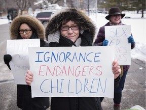 Pro-sex education demonstrators hold signs in opposition to a protest opposing Ontario's new sex education curriculum in front of Queen's Park in Toronto on Tuesday, February 24, 2015.