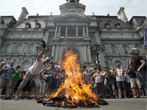 Public sector workers light a bonfire as they protest protest against proposed pension changes in front of city hall Tuesday, June 17, 2014 in Montreal.