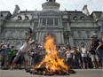 Public sector workers light a bonfire as they protest protest against proposed pension changes in front of city hall Tuesday, June 17, 2014 in Montreal.