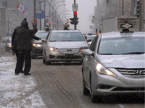 Taxi drivers make their way through downtown during a protest against unregulated transport services like Uber, Thursday, February 19, 2015 in Montreal.THE CANADIAN PRESS/Ryan Remiorz