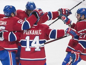 Canadiens' Tomas Plekanec (14) celebrates with teammates Sergei Gonchar (55), P.K. Subban (76) and Alex Galchenyuk after scoring against the New Jersey Devils during second period NHL hockey action in Montreal, Saturday, February 7, 2015.