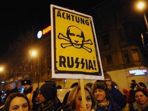 Protesters hold a banner with a text "Attention Russia!" during a demonstration one-day before a visit by Russian President Vladimir Putin on Feb. 16, 2015, in Budapest.