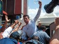 Leopoldo Lopez (C), an ardent opponent of Venezuela's socialist government facing an arrest warrant after President Nicolas Maduro ordered his arrest on charges of homicide and inciting violence, is escorted by the national guard into a vehicle after he turned himself in, during a demonstration in Caracas, on February 18, 2014.