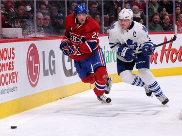 Jacob De La Rose #25 of the Montreal Canadiens and Dion Phaneuf #3 of the Toronto Maple Leafs chase the puck into the corner during an NHL game at the Bell Centre on Feb. 28, 2015 in Montreal, Quebec, Canada.