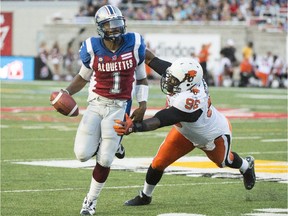Alouettes quarterback Troy Smith breaks away from B.C. Lions defensive-lineman Khalif Mitchell during CFL game at Montreal's Molson Stadium on  July 4, 2014.