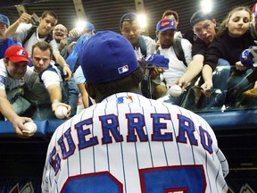 The Expos' Vladimir Guerrero signs autographs before the team's final home game of the season against the Atlanta Braves at Olympic Stadium on Sept. 17, 2003.