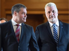 Former education minister Yves Bolduc, left, walks with Quebec Premier Philippe Couillard on their way to a caucus meeting, Feb. 26, 2015 at the legislature in Quebec City.