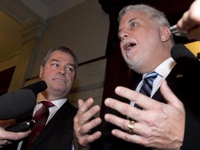 Quebec Premier Philippe Couillard reacts to the resignation of Former Education Minister Yves Bolduc, left, following a caucus meeting, Thursday, February 26, 2015 at the legislature in Quebec City.