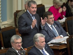 Quebec Education Minister Yves Bolduc rises during question period Tuesday, September 30, 2014 at the legislature in Quebec City.