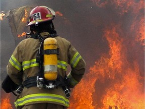 A firefighter walks to a fire.