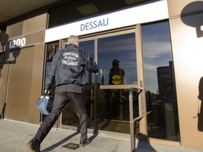 An agent from the Competition Bureau enters a building that houses the offices of Dessau, an engeneering company in Laval north of Montreal, Tuesday, Nov, 6, 2012.