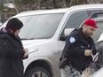 Montreal police investigates a BMW SUV wit bullets holes  at the scene of a fatal shooting at a parking lot on Robert Boulevard.