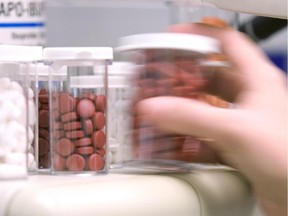 A pharmacist pours pills from a counter at a Jean Coutu pharmacy in downtown Montreal, Wednesday, January 17, 2007.