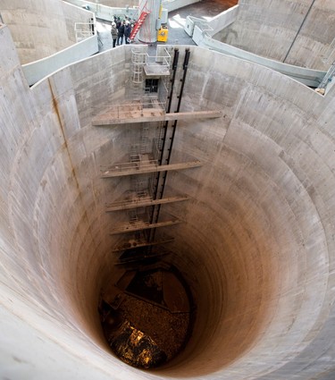 Workers are dwarfed by 4 massive sewage tanks at the Montreal sewage treatment facility in Montreal on Monday March 23, 2015.