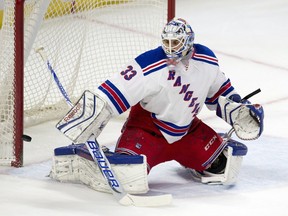 The puck rings off the post behind New York Rangers goalie Cam Talbot during first period NHL action against the Ottawa Senators in Ottawa on Thursday, March 26, 2015.