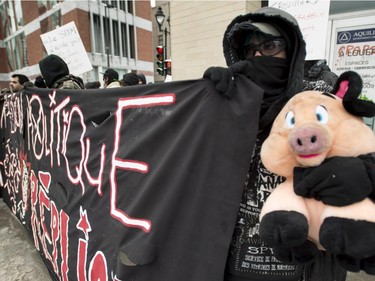 A demonstrator holds a stuffed animal during the annual anti-police brutality demo, Sunday, March 15, 2015, in Montreal.