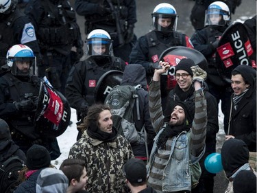 A demonstrator yells out surrounded by riot police during the annual anti-police brutality demo, Sunday, March 15, 2015, in Montreal.