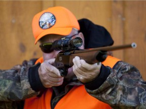 A rifle owner checks the sight of his rifle at a hunting camp property in rural Ontario west of Ottawa on Wednesday Sept. 15, 2010.