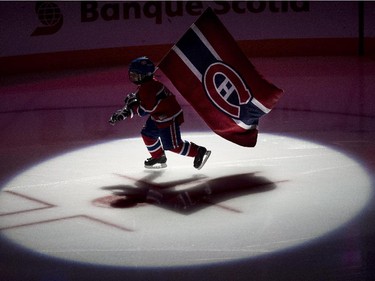 A youngster skates with the Montreal Canadiens flag during pre-game ceremonies prior to the Canadiens facing the Ottawa Senators at the Bell Centre on Thursday, March 12, 2015 in Montreal.