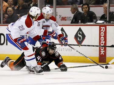 Anaheim Ducks centre Nate Thompson, middle, and Montreal Canadiens defenceman Jeff Petry, left, and defenceman Sergei Gonchar reach for the puck during the second period of an NHL hockey game in Anaheim, Calif., Wednesday, March 4, 2015.