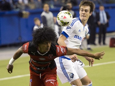 Montreal Impact's Cameron Porter, right, and LD Alajuelense's Porfirio Lopez keep their eyes on the ball during second half CONCACAF semi-final soccer action Wednesday, March 18, 2015, in Montreal.