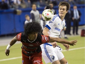 Montreal Impact's Cameron Porter, right, and LD Alajuelense's Porfirio Lopez keep their eyes on the ball during second half CONCACAF semi-final soccer action Wednesday, March 18, 2015, in Montreal.