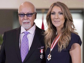 Québec's Céline Dion and husband René Angélil pose for photos after being decorated with the Order of Canada in Quebec City on July 26, 2013. Dion says she has to feed her ailing husband because he can't use his mouth. Angélil, who has doubled as Dion's manager, had surgery in December 2013 to remove a cancerous tumour.