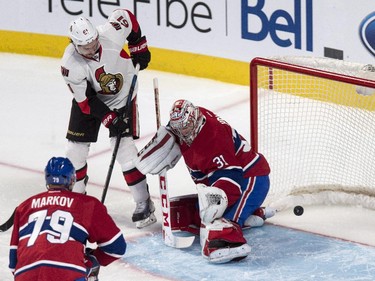 Ottawa Senators' Mark Stone deflects a shot to score past Carey Price as defenseman Andrei Markov looks on during third-period action at the Bell Centre on Thursday, March 12, 2015.