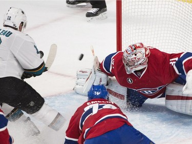 Montreal Canadiens goaltender Carey Price makes a save on San Jose Sharks' Patrick Marleau (12) as Alexei Emelin (74) defends during third period NHL hockey action in Montreal, Saturday, March 21, 2015.