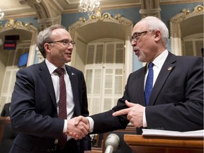 Quebec Finance Minister Carlos Leitao, right, gets a handshake from Treasury Board president Martin Coiteux before presenting a provincial budget, Thursday, March 26, 2015 at the legislature in Quebec City.