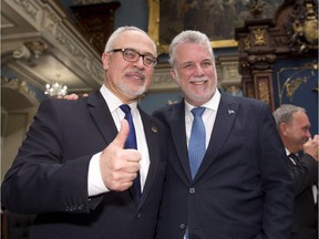Quebec Finance Minister Carlos Leitao, left, gives the thumbs up while standing with Premier Philippe Couillard, before presenting a provincial budget, Thursday, March 26, 2015 at the legislature in Quebec City.