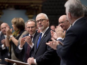 Quebec Finance Minister Carlos Leitão, centre, is applauded by members of the government as he presents a provincial budget, Thursday, March 26, 2015 at the legislature in Quebec City.