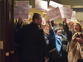 A security guard tries to keep out anti-austerity protesters from a speech by Quebec Finance Minister Carlos Letaio at a Chamber of Commerce luncheon, Monday, March 30, 2015 in Montreal.