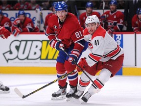 Playing in his first NHL career game, Danny Biega #41 of the Carolina Hurricanes defends against Lars Eller during the game at the Bell Centre on March 19, 2015.
