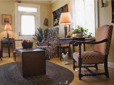 Comfy looking antique chairs are gathered around an old wooden chest table in the family room on the ground floor.