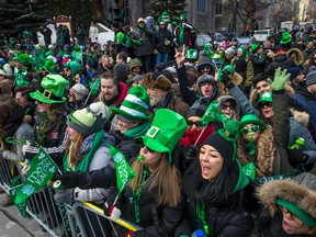 People watch the St. Patrick's parade on Ste-Catherine St. W. from the corner of Bishop St. in downtown Montreal on Sunday, March 22, 2015.