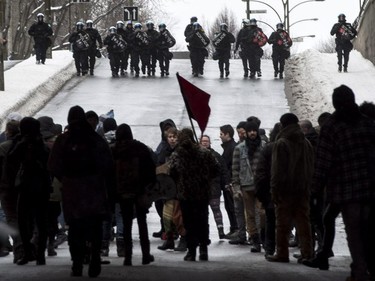 Demonstrators turn away as riot police move in during the annual anti-police brutality demo, Sunday, March 15, 2015, in Montreal.