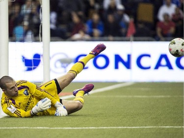 Montreal Impact goalkeeper Evan Bush makes a save as they face LD Alajuelense during second half CONCACAF soccer semi-final action Wednesday, March 18, 2015, in Montreal.