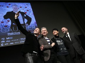 French fashion designer Jean-Paul Gaultier (C), flanked by The Grand Palais Museum president Jean-Paul Cluzel (R), the curator of museum des Beaux arts of Montreal, Nathalie Bondil and the curator of the exhibition Thierry-Maxime Loriot (L), pose for a selfie, during a press conference prior to the opening of the exhibition devoted to him on March 30, 2015 in Paris.