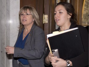 Francine Charbonneau, left, Minister of Families, Minister responsible for Seniors and Minister responsible for Anti-Bullying, walks by reporters with her press attaché Lea Nadeau, Wednesday, March 25, 2015 at the legislature in Quebec City. Charbonneau refused to comment on a personal Facebook post that offended students.
