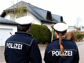 Policemen stand in front of a house in a small street on March 26, 2015, in Montabaur, soutwestern Germany, from where the co-pilot of the crashed Germanwings plane came. Germany's interior minister said there was no indication the co-pilot who French authorities say deliberately crashed a Germanwings plane into the French Alps had a terrorist background.