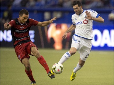 Montreal Impact's Ignacio Piatti, right, and LD Alajuelense's Kenner Gutierrez fight for the ball during second half CONCACAF semi-final soccer action Wednesday, March 18, 2015, in Montreal.
