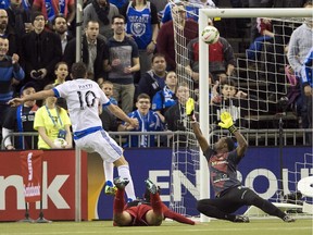 Montreal Impact's Ignacio Piatti scores the first goal against LD Alajuelense goalkeeper Lewis Dexter during first-half CONCACAF semi-final soccer action Wednesday, March 18, 2015, in Montreal.