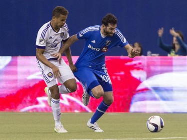 Orlando City SC's Tyler Turner tugs on Montreal Impact's Ignacio Piatti's jersy during second half MLS action on Saturday, March 28, 2015, in Montreal.