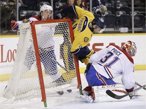 Nashville Predators center Filip Forsberg (9), of Sweden, knocks the net loose as he collides with Montreal Canadiens left wing Jacob De La Rose (25), of Sweden, as goalie Carey Price (31) covers the puck in the first period of an NHL hockey game Tuesday, March 24, 2015, in Nashville, Tenn.