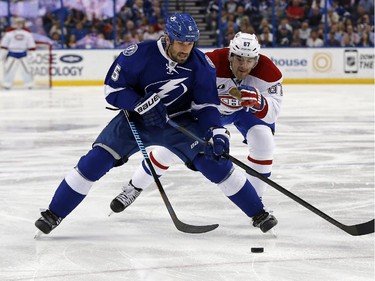 Tampa Bay Lightning's Jason Garrison and Montreal Canadiens' Max Pacioretty chase the puck during the first period Monday, March 16, 2015, in Tampa, Fla.