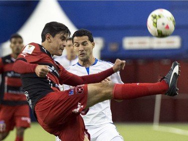 LD Alajuelense's Jose Salvatierra kicks the ball away form Montreal Impact's Dilly Duka during first half CONCACAF soccer semi-final action Wednesday, March 18, 2015, in Montreal.