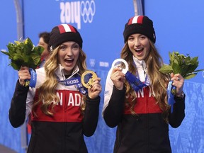 Justine Dufour-Lapointe (left) holds her gold medal and sister Chloe holds her silver for women's moguls at the Sochi Games in 2014.