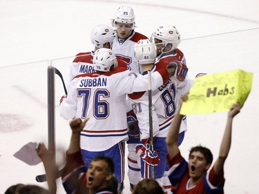 As Montreal Canadiens fans celebrate, Canadiens' Lars Eller (81), of Denmark, is congratulated on his goal against the Arizona Coyotes by teammates P.K. Subban (76), Jacob De La Rose (25), of Sweden, Andrei Markov (79), of Russia, and Devante Smith-Pelly, right, during the second period of an NHL hockey game Saturday, March 7, 2015, in Glendale, Ariz.